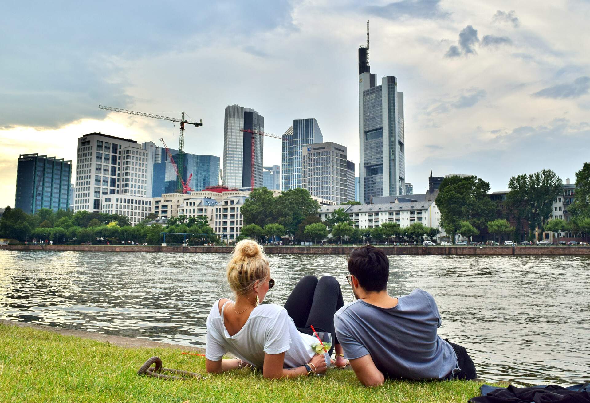 DEST_GERMANY_FRANKFURT AM MAIN_Couple laying on grass at the edge of the Main River_shutterstock-premier_1058256620